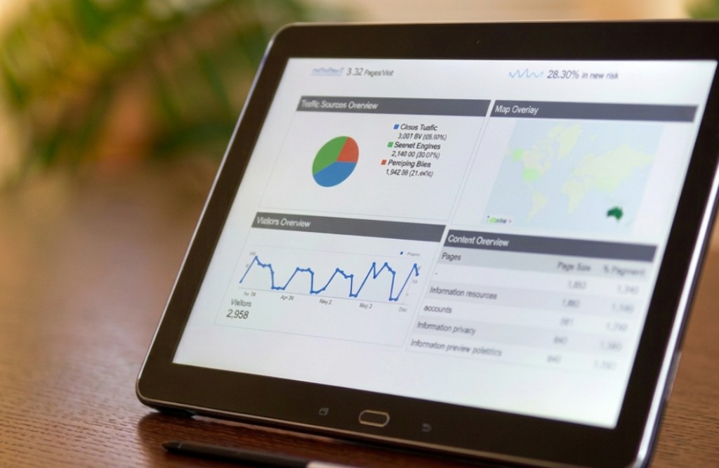 Analytics dashboard on a tablet showing visitor trends and traffic sources